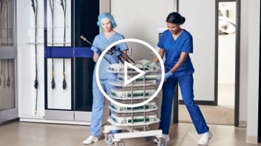 Two women in scrubs wheeling an endoscopy cart